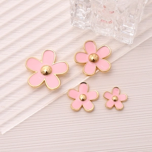 Close-up of pink alloy five-petal flower charms with gold edges for DIY jewelry and phone cases