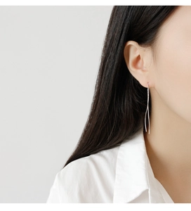 Close-up of minimalist S925 sterling silver S-shaped long threader earrings on model