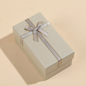 Detailed top view of a rectangular silver-grey jewelry gift box with a silk ribbon bow