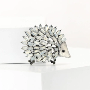 Detailed view of silver hedgehog brooch with white rhinestones and black eye crystals