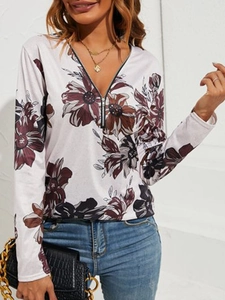 Detailansicht des Damen-Langarmshirts mit rotem Blumendruck und V-Ausschnitt mit Metall-Reißverschluss