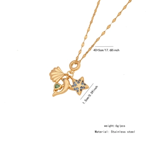 Detail view of gold necklace with shell and dolphin charms and size measurements