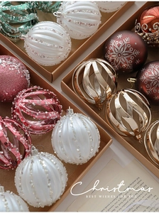 Close-up of assorted 8cm Christmas ball ornaments in a kraft box with glitter and patterns