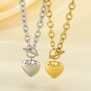 Detailed close-up of gold and silver heart pendant necklaces with OT buckle closures