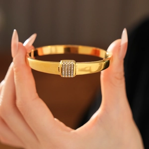 Gros plan d'un bracelet en acier titane doré avec un rectangle incrusté de cristaux
