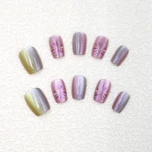 Détails d'ongles cat-eye avec motifs floraux violets et dégradé jaune brillant
