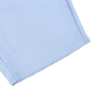 Detailed close-up of light blue linen shirt fabric texture and durable double-stitch seams