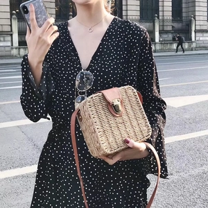 Minimalist straw crossbody bag with brown PU flap and woven texture on a street model