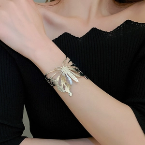 Detailed view of hollow butterfly cuff bracelet in shiny gold with hammered metal texture