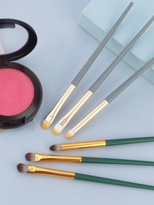 Flat lay of professional eye makeup brushes and palette on a blue geometric background