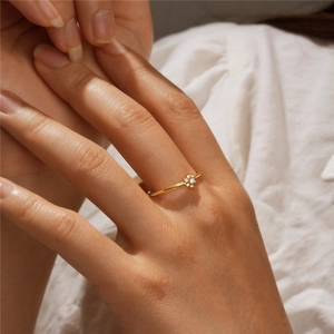 Close-up of a delicate S925 silver flower ring with sparkling zircon in a gold finish