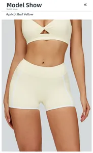 Detail view of apricot yellow yoga shorts with white contrast binding and side pockets