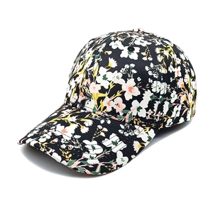 Vue détaillée d'une casquette de baseball à fleurs avec motifs blancs et roses sur noir