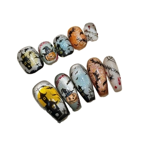 Hand-painted Halloween press-on nails with pumpkin bat castle and spider web designs