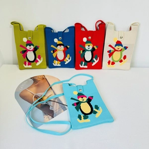 Detailed view of five colorful knitted snowman mini crossbody bags with penguin embroidery