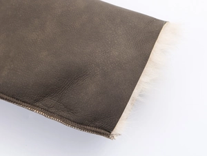 Macro shot of dark brown pebbled leather texture and soft white faux fur lining details