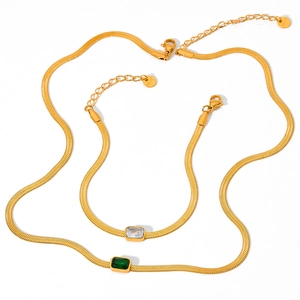 Set di gioielli a catena serpente dorata con pietre di zircone verde smeraldo e trasparente