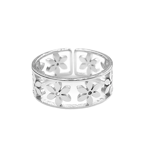 Macro detail of silver titanium steel ring featuring hollow flower patterns on white background