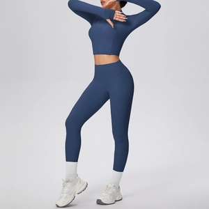 Détail d'un ensemble de yoga avec manches à trou pour pouce et haut court zippé bleu