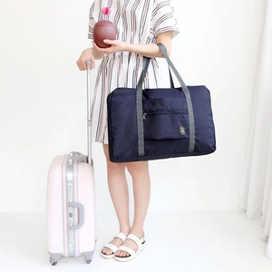 Large capacity navy blue folding travel bag on pink suitcase for easy transport
