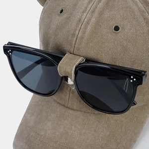 Dettaglio cappello da baseball kaki lavato con occhiali da aviatore sulla visiera