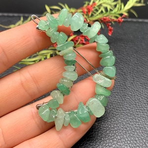 Detail of crescent moon hair clip with green natural crystal stones and silver metal wire