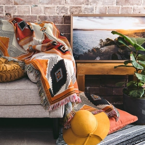 Detail of bohemian geometric woven blanket with colorful tassels and textured jacquard pattern
