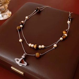 Detail of double-layer necklace with pearls and tiger eye stone on leather jewelry box