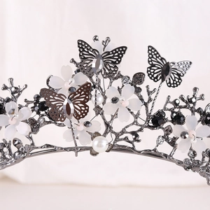 Macro detail of metal butterflies and white flowers on a vintage bridal crown