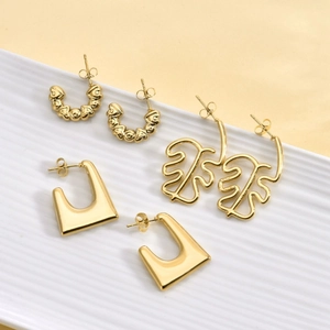 Three pairs of vintage 18K gold plated stainless steel geometric earrings on white tray