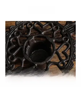 Macro shot of cast iron tea warmer with vintage openwork heart and floral textures
