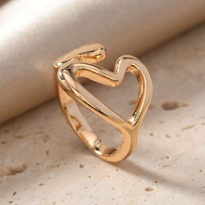 Macro detail of adjustable golden heart ring on an elegant stone pedestal background