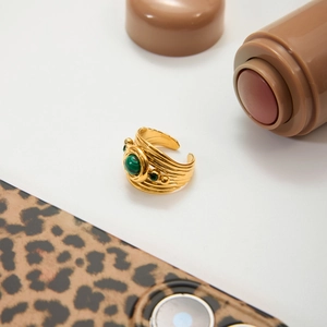 Detailed view of vintage gold ring with green malachite stone and textured relief patterns
