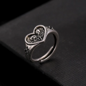 Macro-opname van een gothische hartring met schedels en een geoxideerde afwerking