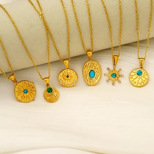 Bohemian gold plated necklaces with turquoise and malachite pendants on textured fabric