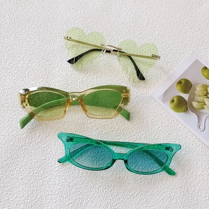 Three pairs of green retro oval sunglasses for men and women on a white textured background