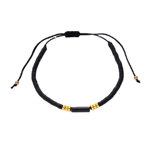 Minimalist handmade beaded bracelet with black clay discs, gold accents and adjustable cord