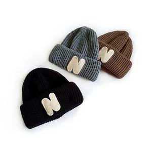 Kids ribbed knit beanies with N patches in black, grey and brown on white background