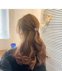 Rear view of a model wearing a pink rose floral hair claw clip for a half-up hairstyle