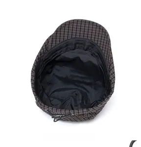 Detailed interior view of a brown plaid beret hat featuring adjustable drawstring and black lining