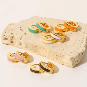 Detail of colorful enamel hoop earrings in gold plated titanium steel on stone