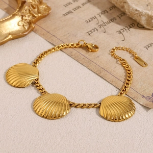 Detailed macro view of an 18K gold plated chain bracelet with three seashell charms