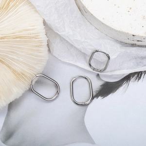 Minimalist silver oval stainless steel hoop earrings with a geometric U-shaped design