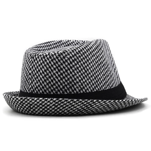 Detailed view of the houndstooth pattern fabric and black ribbon on the fedora hat