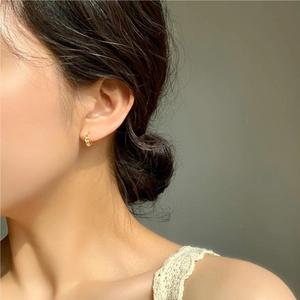 Close-up of a model wearing minimalist golden 925 sterling silver chain link hoop earrings