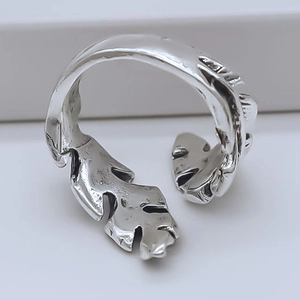 Detailed close-up of a vintage silver feather-patterned open ring with an oxidized finish