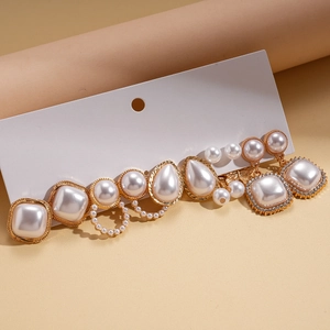 Detail of ten-piece vintage gold pearl and rhinestone earrings set on white display card