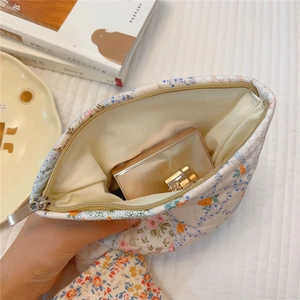 Quilted cotton floral pouch showing inner yellow lining with gold cosmetic case