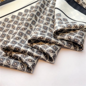 Detail of silk scarf with grey and black geometric patterns on white background