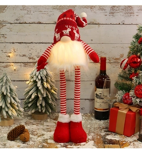 Close-up of a glowing Christmas gnome with LED light on a cozy wooden holiday background